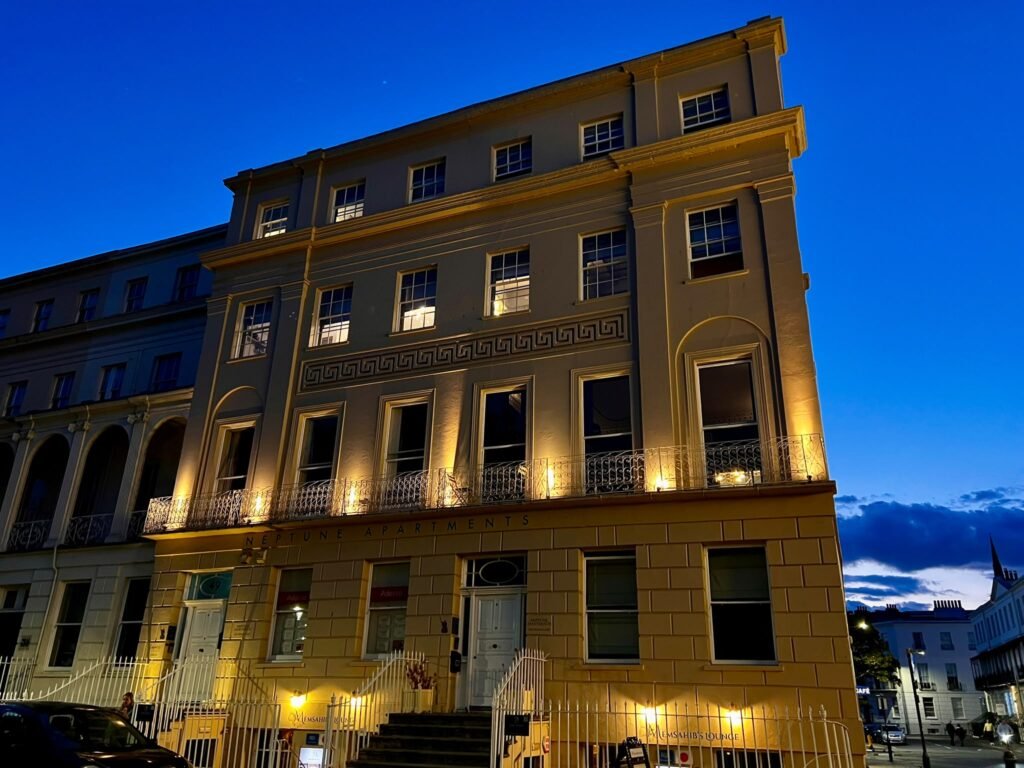 Regency building illuminated against a deep blue evening sky in Cheltenham