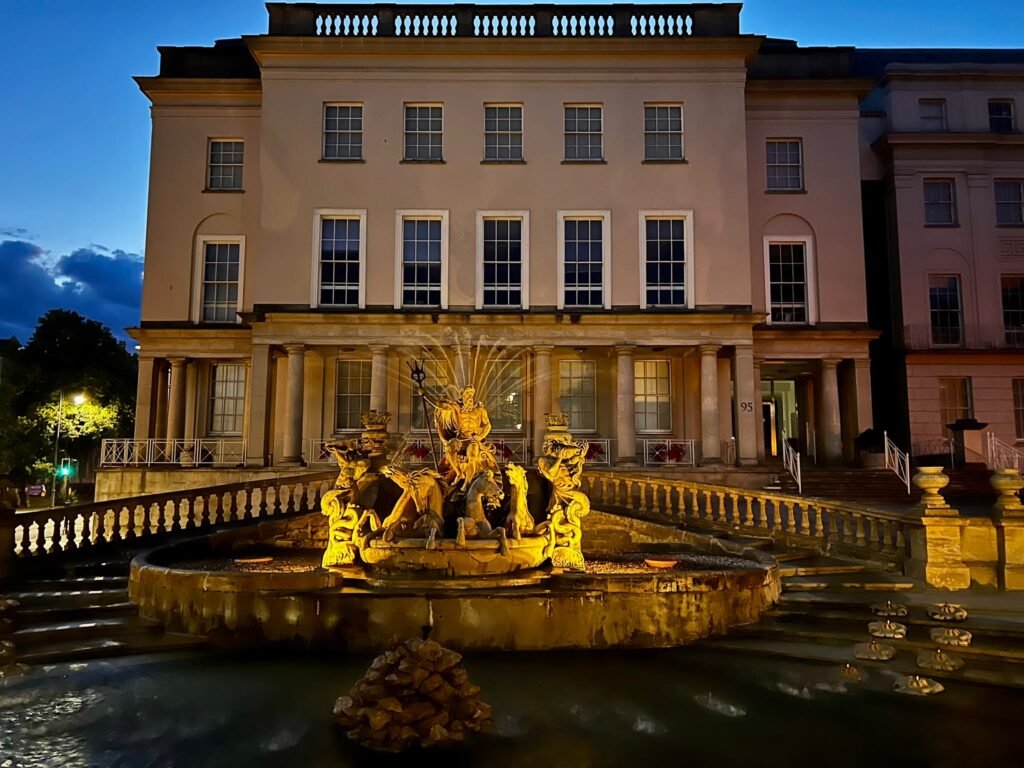 Neptune's Fountain illuminated at night on the Promenade in Cheltenham