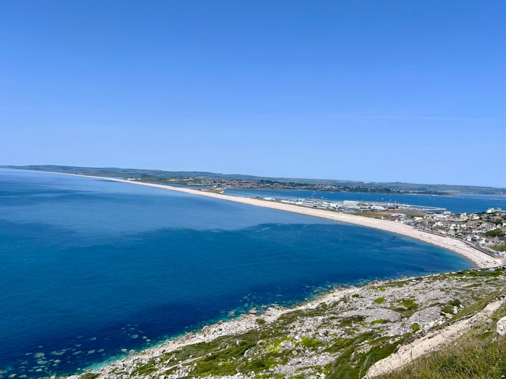 Wide coastal view from the Isle of Portland towards Chesil Beach and the Dorset coast