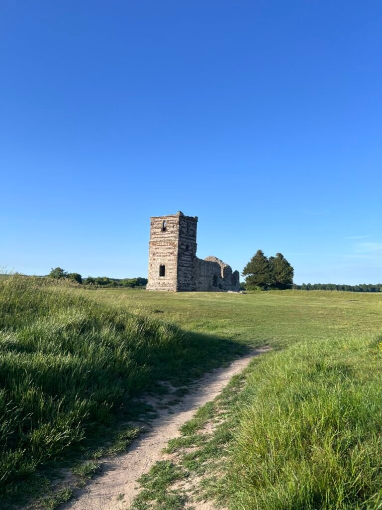 Narrow grassy path leading towards the ruins of Knowlton Church in Dorset