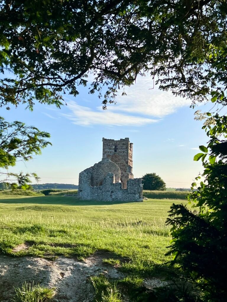Knowlton Church ruins seen through trees in the Dorset countryside