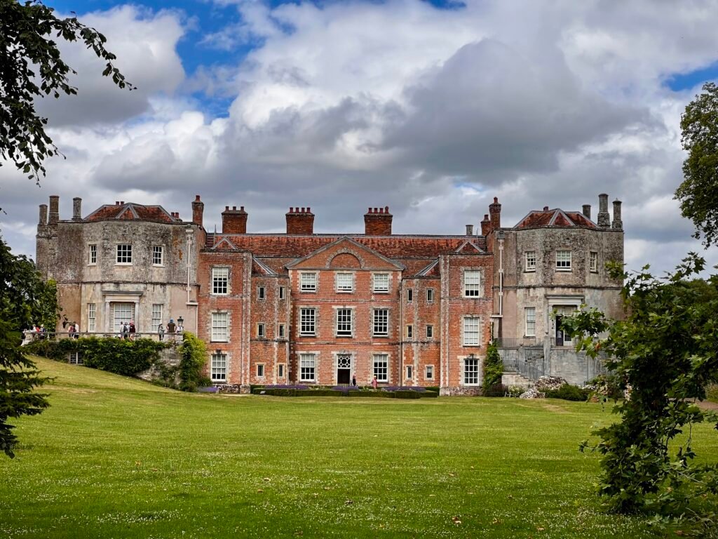 National Trust historic house behind a formal garden and lily pond
