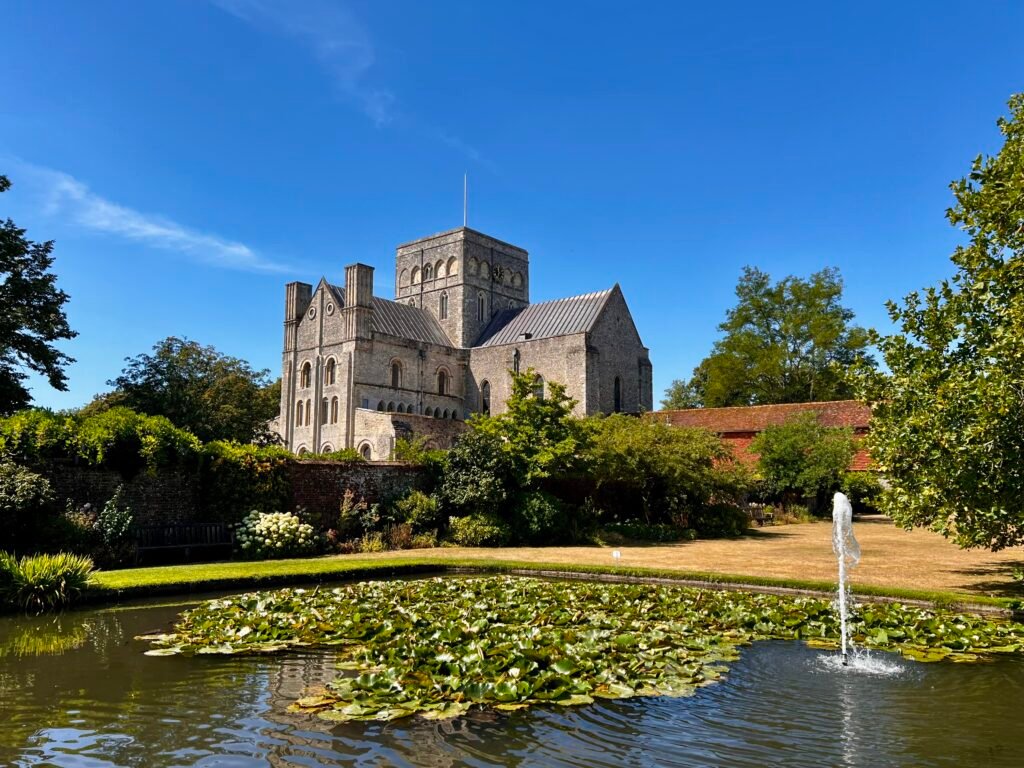 Hospital of St Cross and Almshouse of Noble Poverty in Winchester beyond a garden pond and fountain
