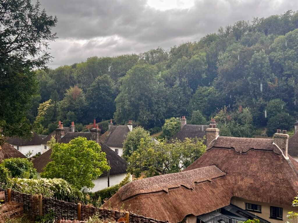 Thatched cottages in Milton Abbas surrounded by wooded Dorset hills