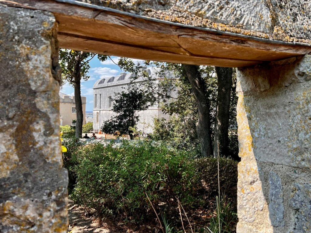 Portland Castle framed through an opening in a garden wall