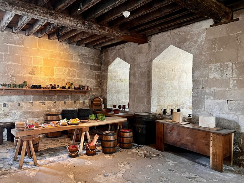 Reconstructed Tudor kitchen with tables, barrels and food displays inside Portland Castle