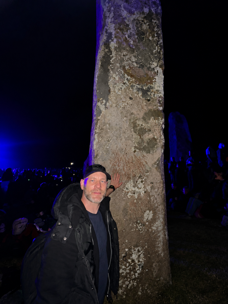 A visitor resting a hand against one of the Stonehenge stones during the overnight Summer Solstice gathering.
