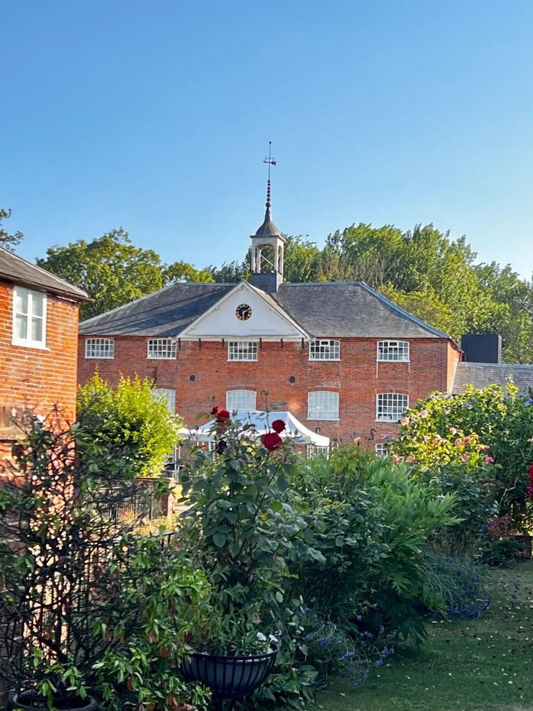 Whitchurch Silk Mill seen beyond riverside gardens in Whitchurch Hampshire