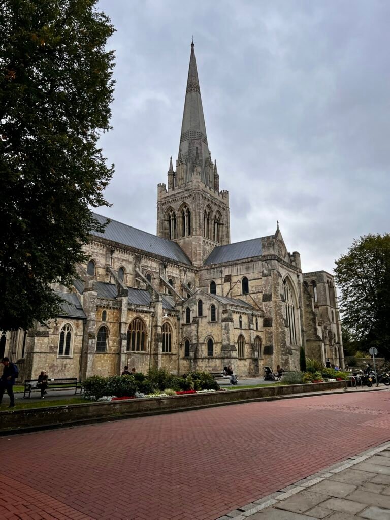 Exterior of Chichester Cathedral with its tall stone spire rising above the historic building