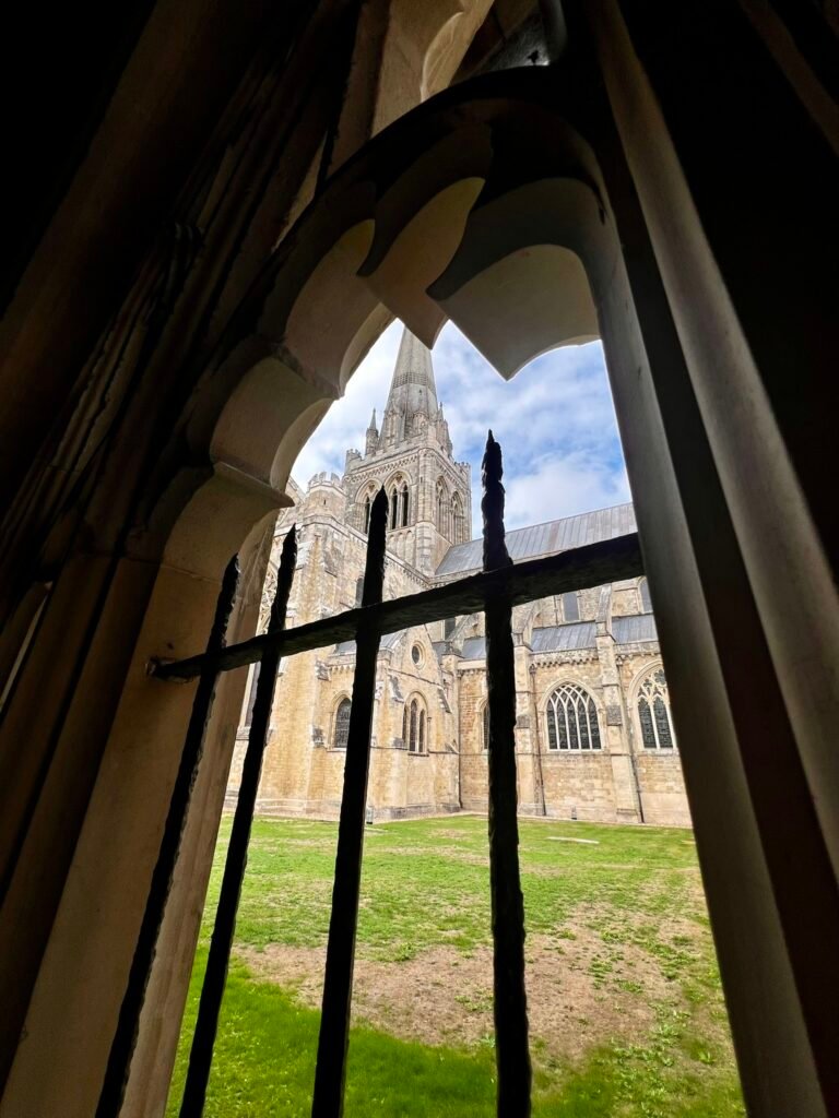 Chichester Cathedral spire framed through a historic stone opening