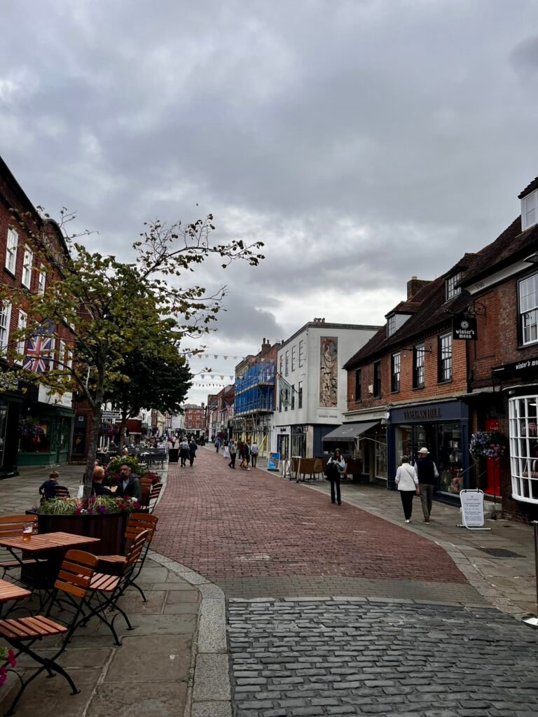 Pedestrianised street in Chichester city centre with shops, cafés, bunting and people