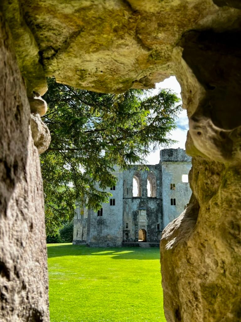 Old Wardour Castle seen through a rocky opening in the grotto