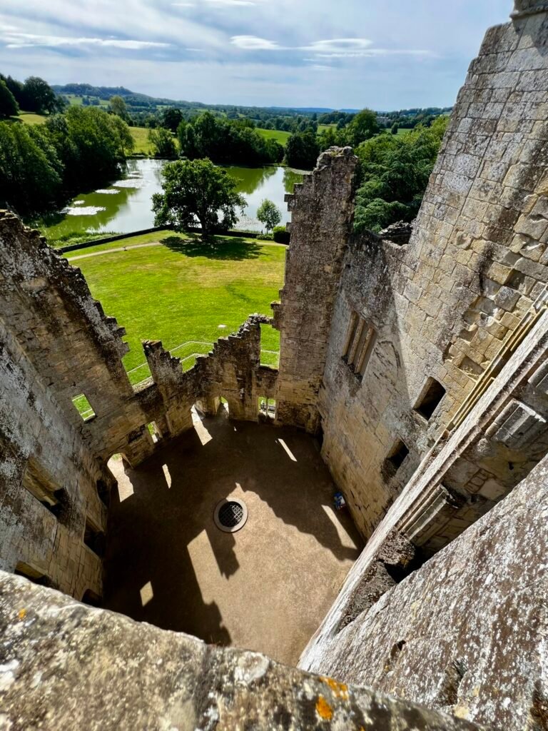 View down into the roofless interior of Old Wardour Castle with the lake beyond