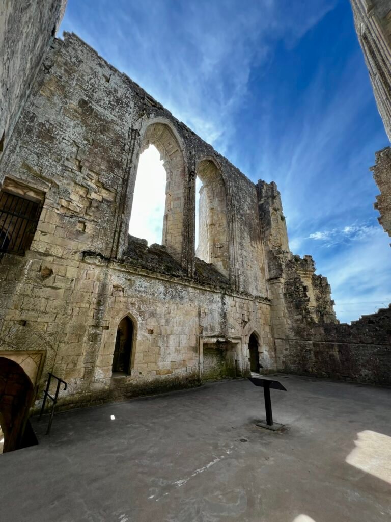 Tall ruined stone walls and arched window openings inside Old Wardour Castle