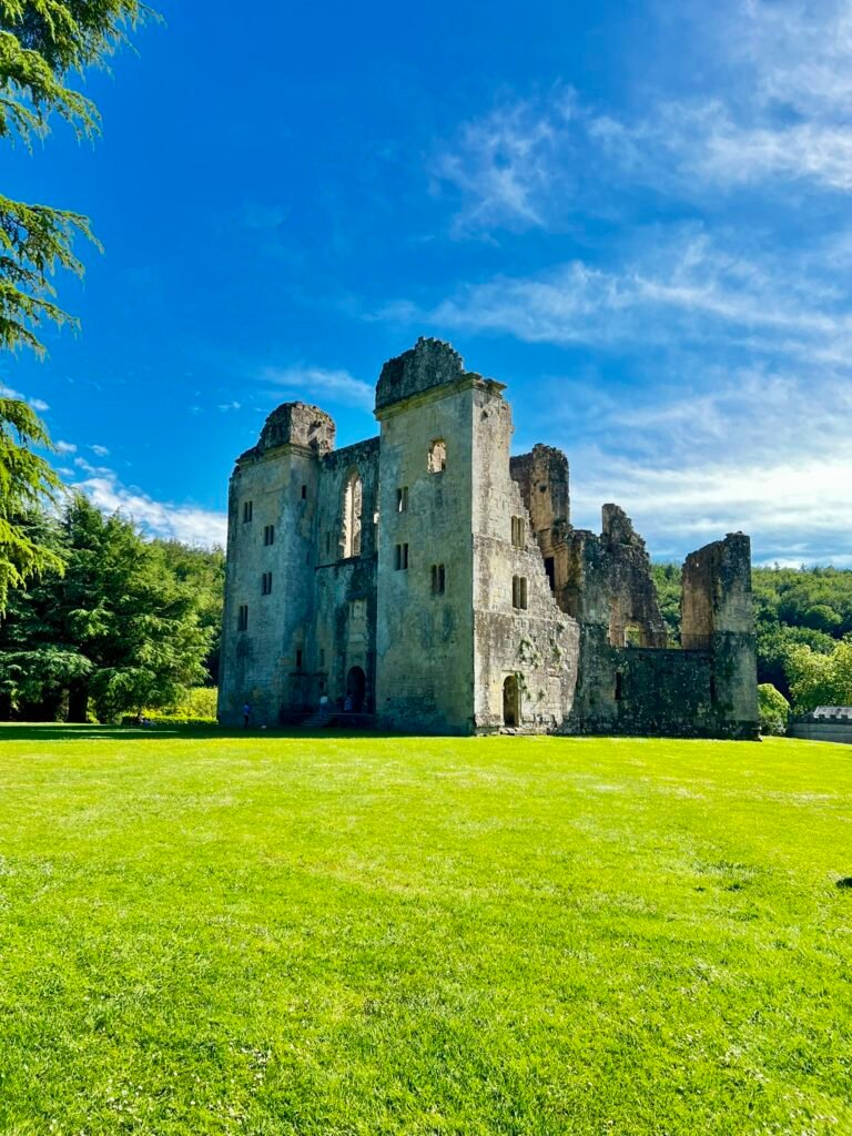 Old Wardour Castle ruins standing beside a wide green lawn in Wiltshire