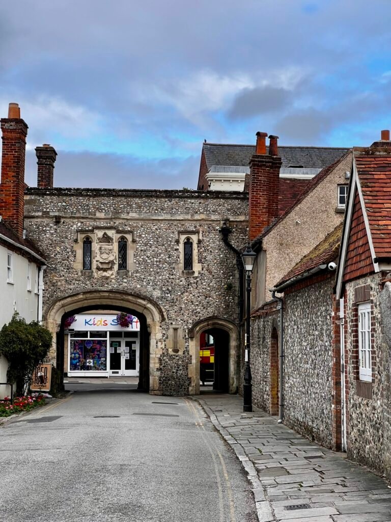 Historic flint and stone archway viewed along a narrow street in Chichester