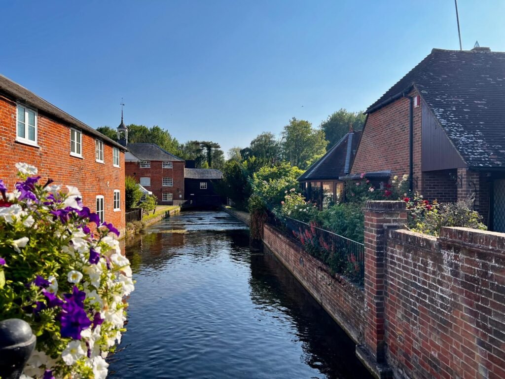 River Test flowing past historic red-brick mill buildings in Whitchurch, Hampshire
