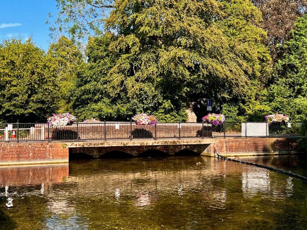 Flower-covered bridge across the River Test in Whitchurch Hampshire