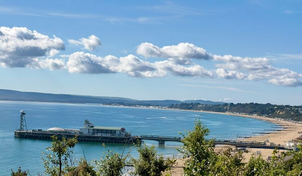 Bournemouth Pier stretching into the sea, with sandy beach and coastline on a sunny day