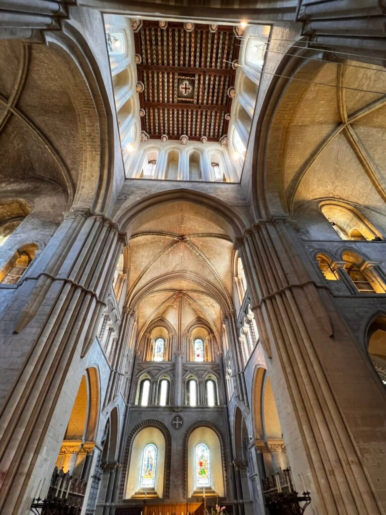 Soaring stone arches and vaulted ceilings beneath a patterned timber roof at St Cross.
