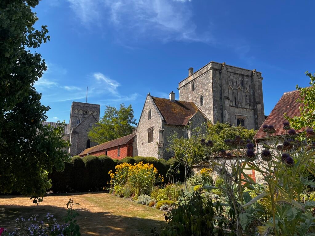 Medieval towers and historic buildings rising above the gardens at St Cross in Winchester.