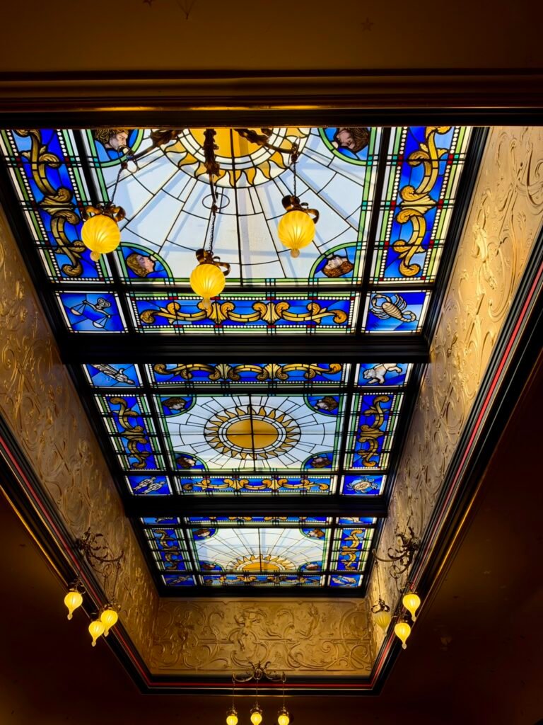 Blue stained-glass Main Hall roof at Russell-Cotes Museum decorated with the sun and zodiac