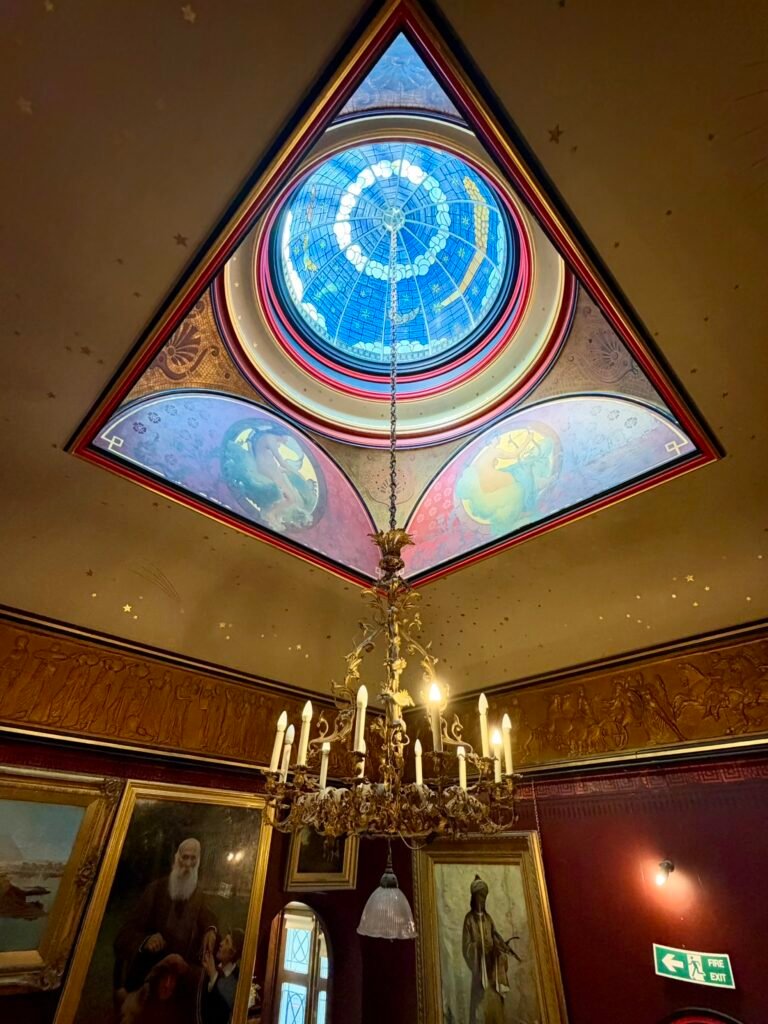 Circular blue stained-glass dome over the Russell-Cotes staircase, with night-sky decoration