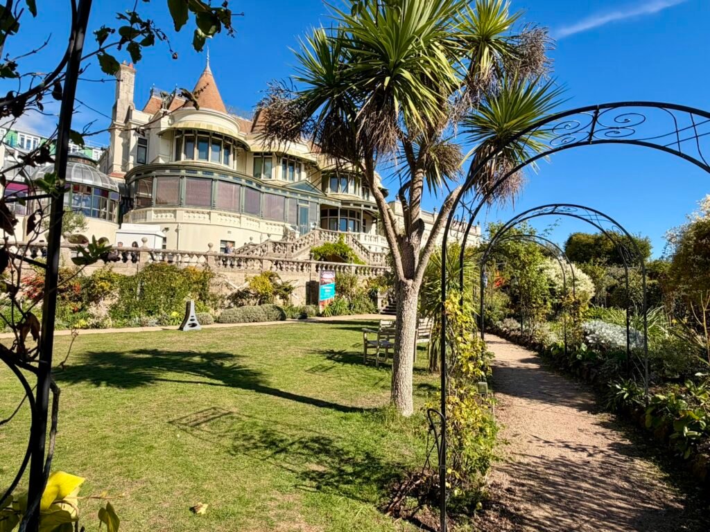Subtropical palm trees and garden arches in front of Russell-Cotes Museum's Victorian villa