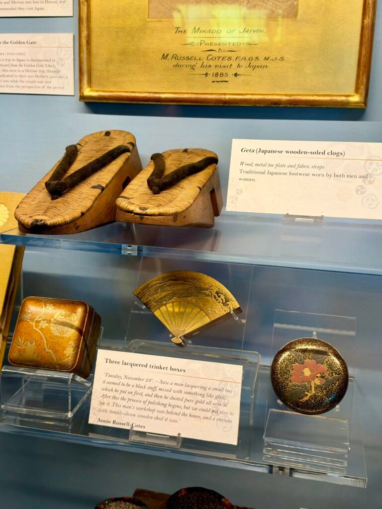 Japanese wooden geta sandals, a folding fan and lacquered boxes displayed at Russell-Cotes Museum