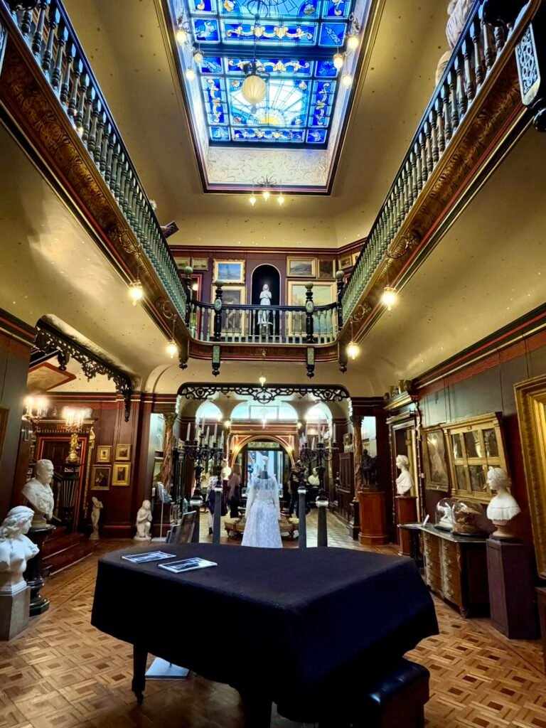Double-height Main Hall at Russell-Cotes Museum with paintings, sculptures, balconies and blue skylight