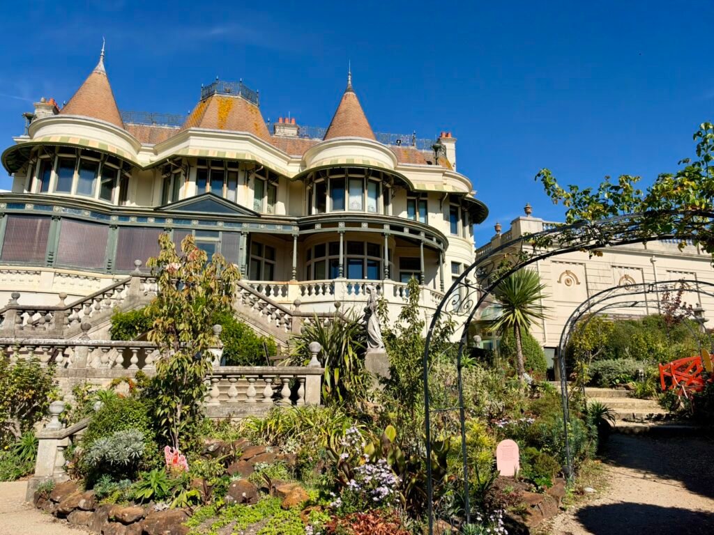 Russell-Cotes Victorian house rising above planted terraces, palms and iron arches in Bournemouth