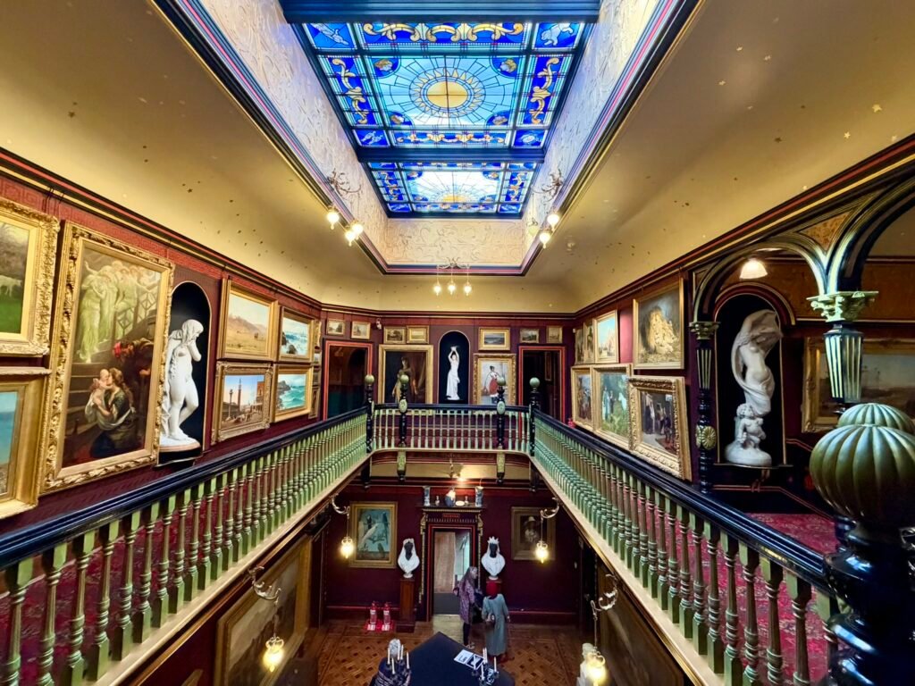 Upper balcony and green-painted balustrades overlooking the Russell-Cotes Main Hall and sculptures