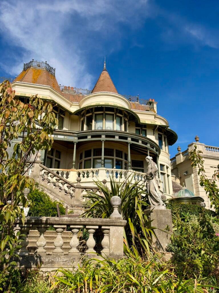 Turreted side facade of Russell-Cotes Museum with an outdoor statue and stone balustrade
