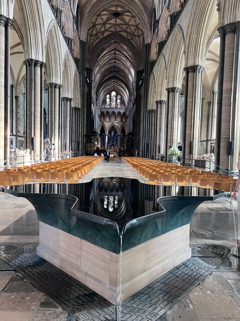 Reflective font, towering Gothic arches and vaulted nave inside Salisbury Cathedral