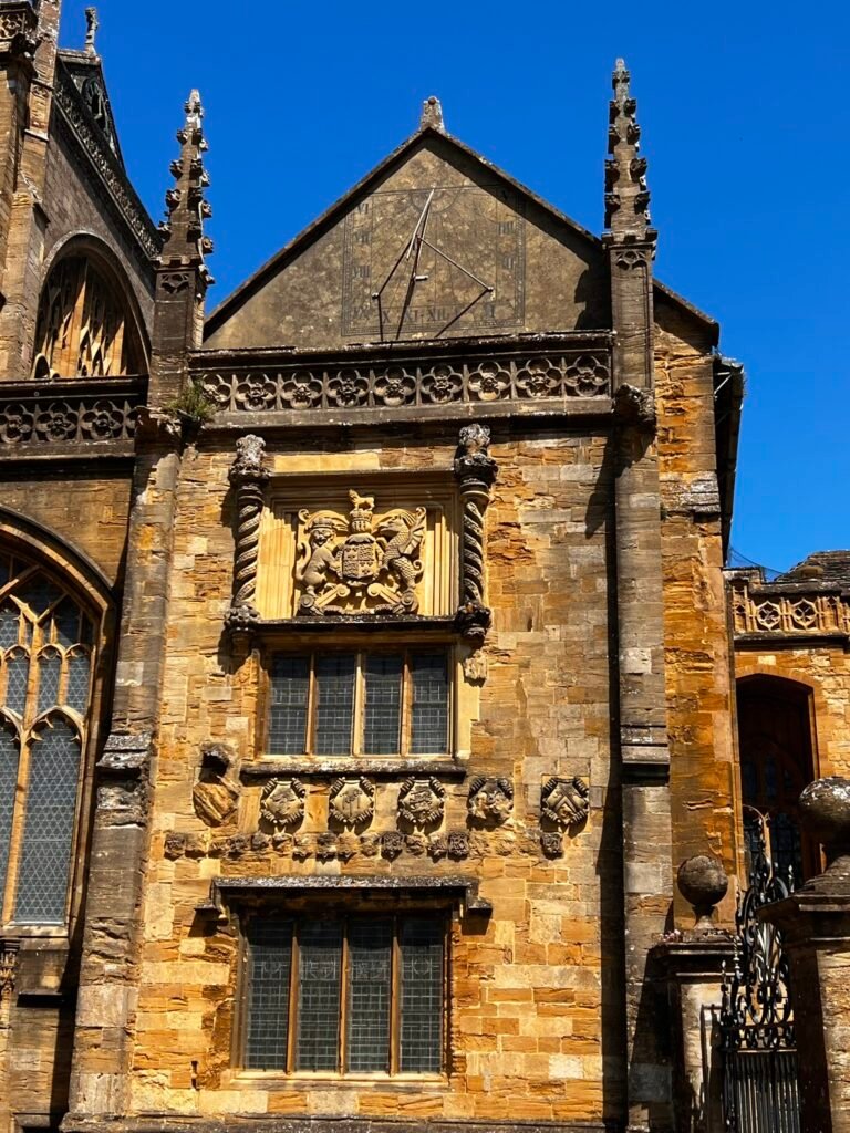 Historic sundial and carved heraldic stonework on Sherborne Abbey in Dorset