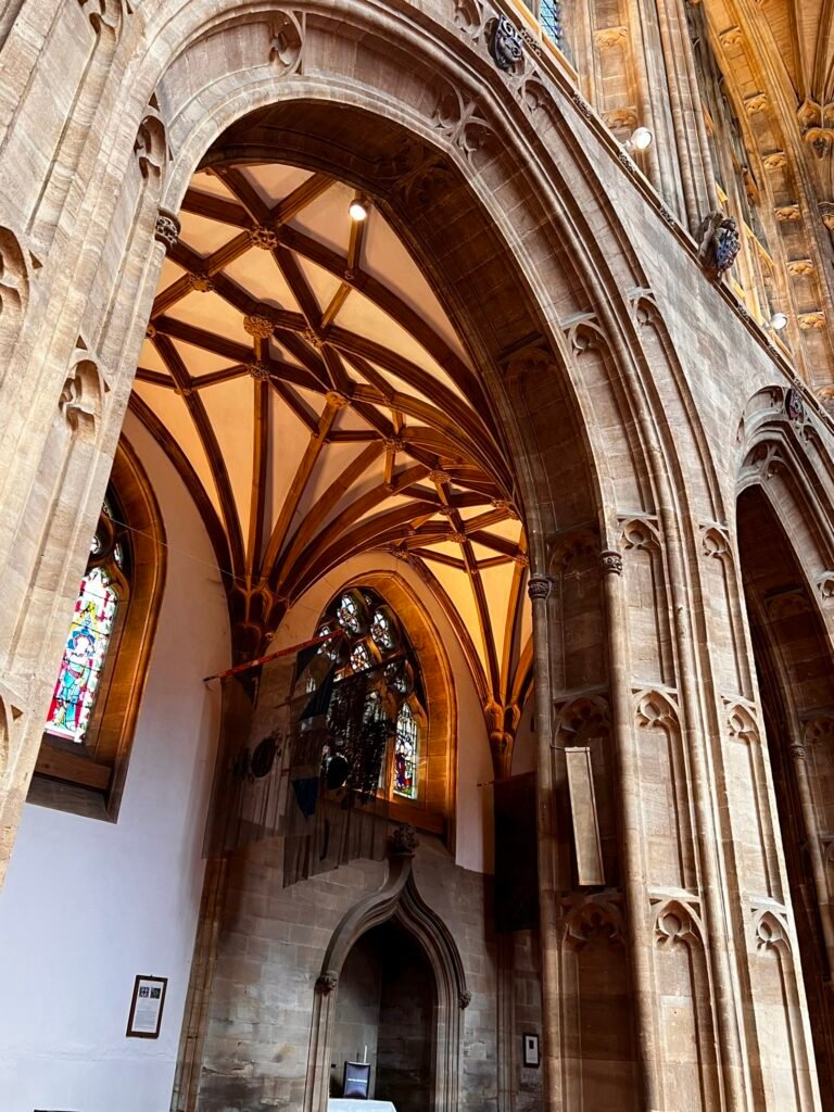 Stone Gothic arches and stained-glass windows inside Sherborne Abbey