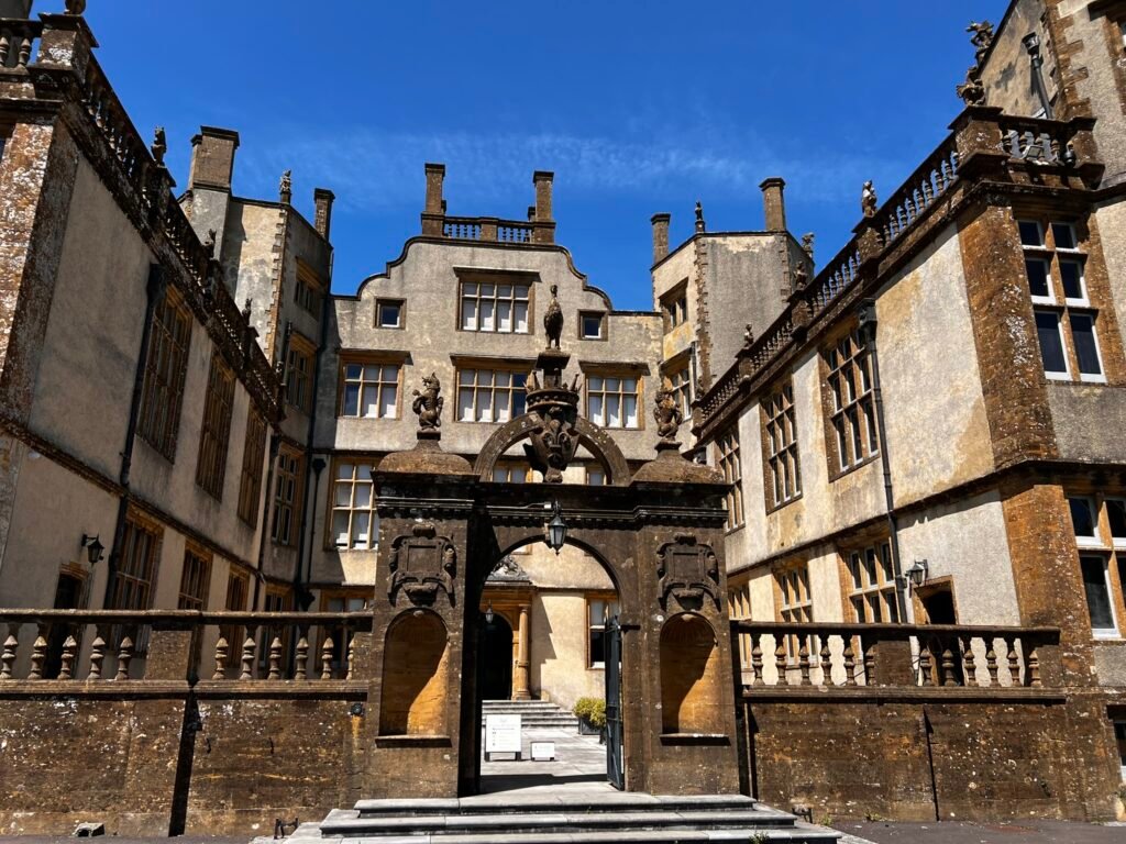 Sherborne Castle and Gardens entrance courtyard with an ornate stone gateway