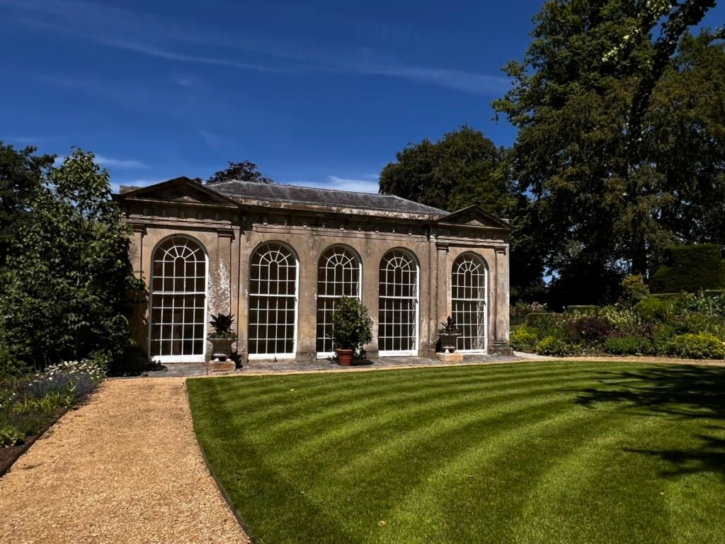 Historic Orangery with five tall arched windows and striped lawn in front