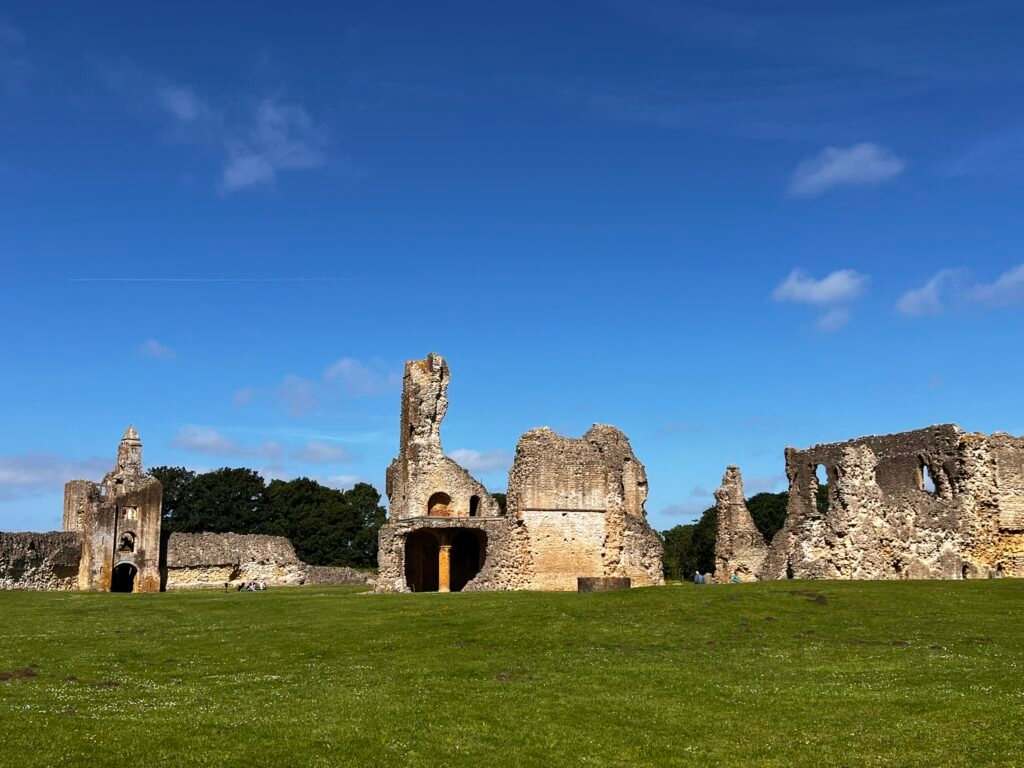 Sherborne Old Castle ruins spread across the lawn beneath a blue sky