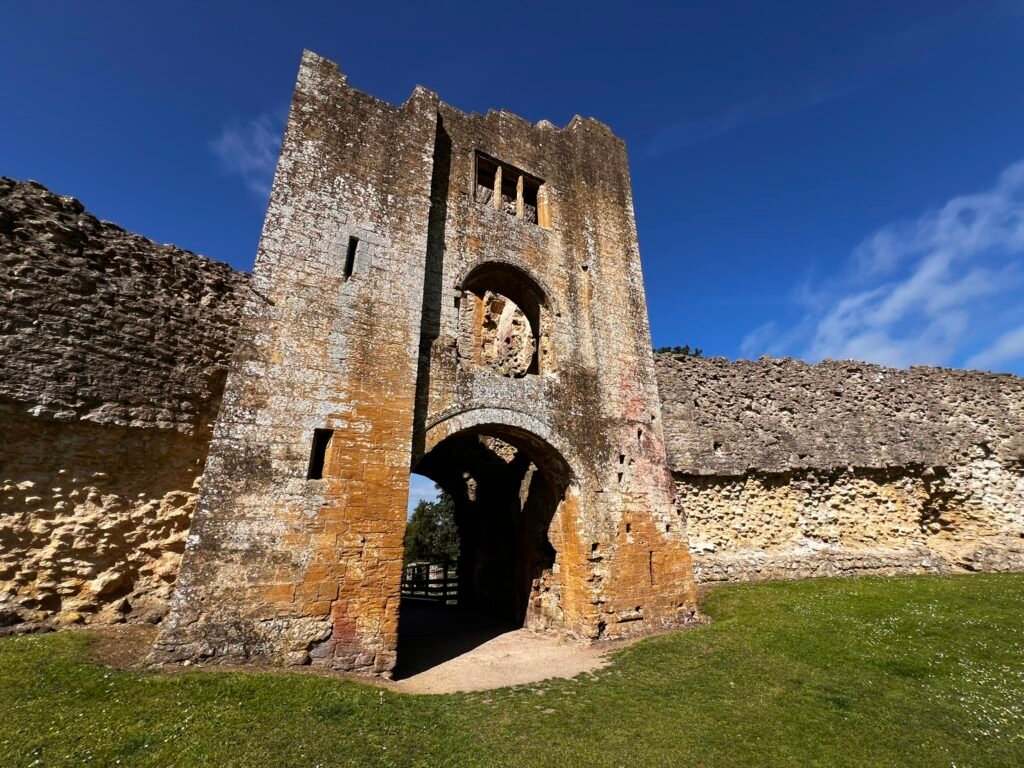 Medieval gatehouse at Sherborne Old Castle with ruined curtain walls on either side