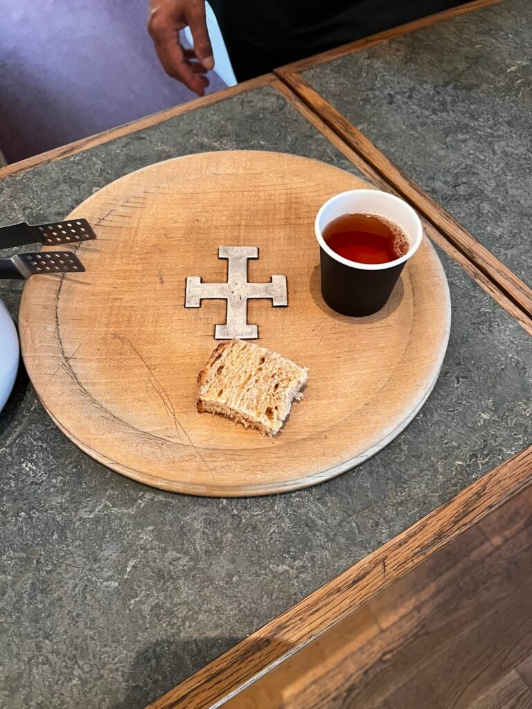 A small cup of ale and piece of bread on the Wayfarer's Dole tray at St Cross.