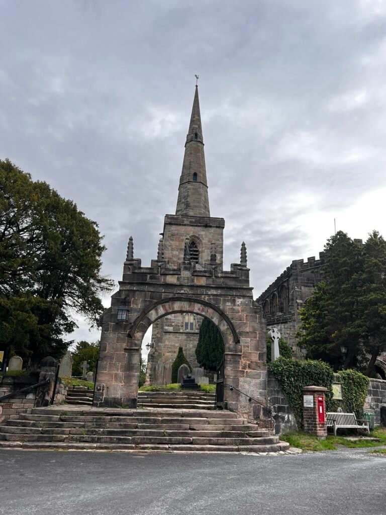 Stone arched gateway and steps with the spire of St Mary's Church rising behind.