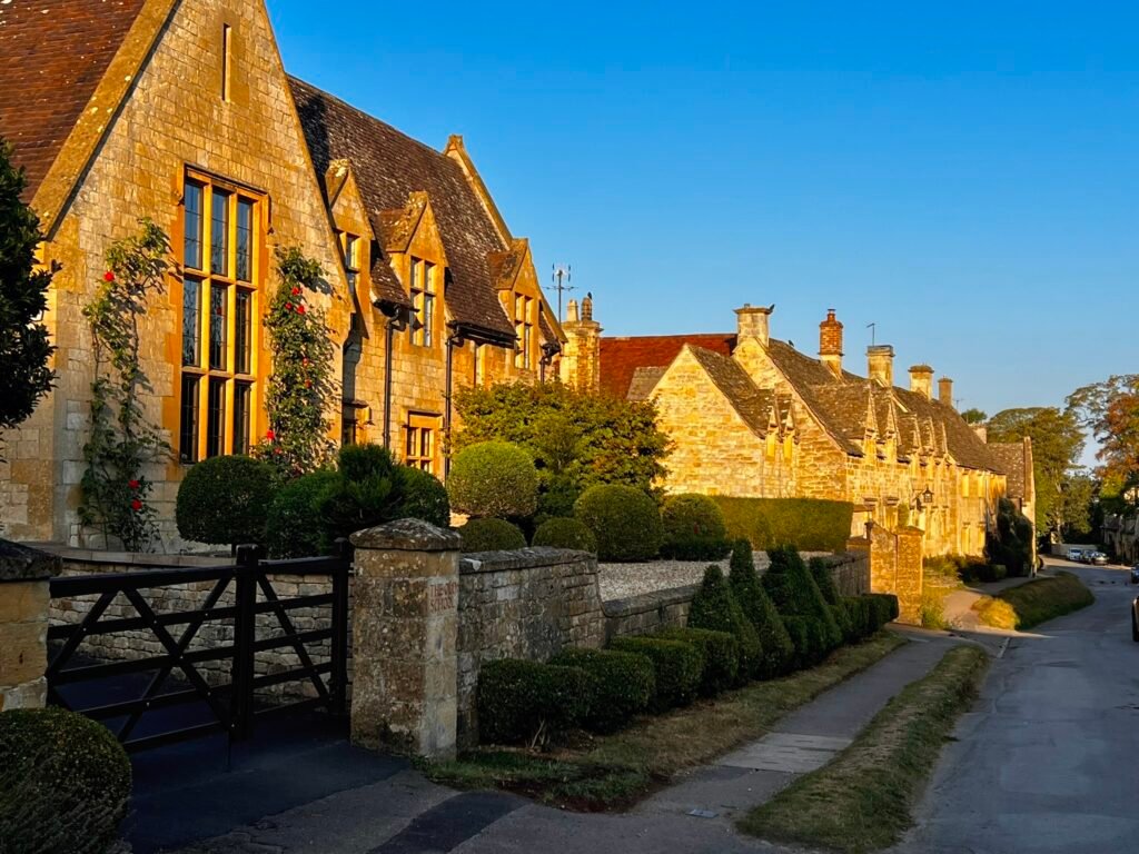 The Old School and a row of golden stone buildings along a street in Stanton