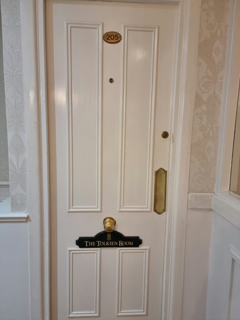 White door of Room 205 at Hotel Miramar, bearing the Tolkien Room nameplate.