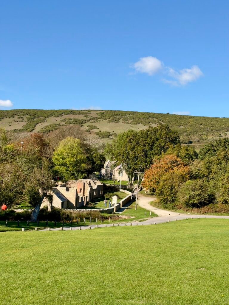 View over Tyneham Village, Dorset, with ruined cottages, green fields and Purbeck hills