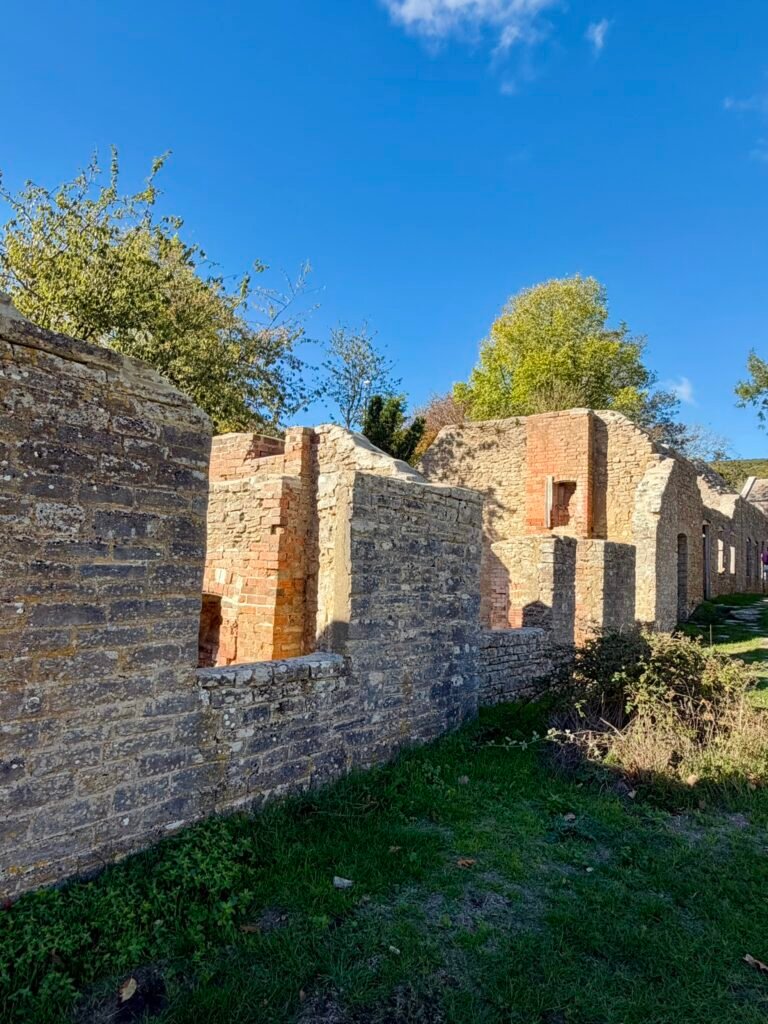 Roofless stone cottages and surviving brick chimneys in the abandoned village of Tyneham, Dorset